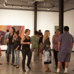 Artist Tony de los Reyes engages Orange County Museum of Art Curator Sarah Bancroft in conversation as patrons enjoying Erin Morrison exhibition.