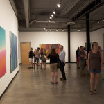 UC Riverside Sweeney Gallery Curator Tyler Stallings talks with CSUF Masters student Wendy Sherman as patrons enjoying Tony de los Reyes exhibition.