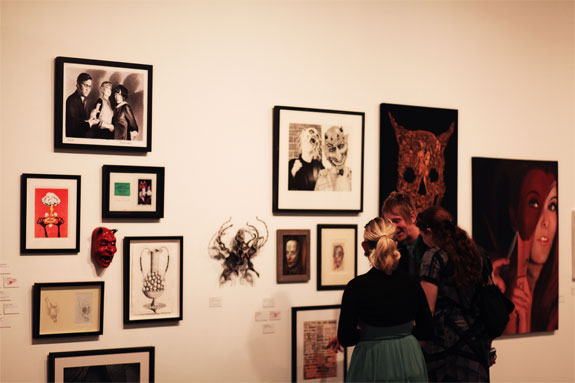 Figures looking at artworks on the wall