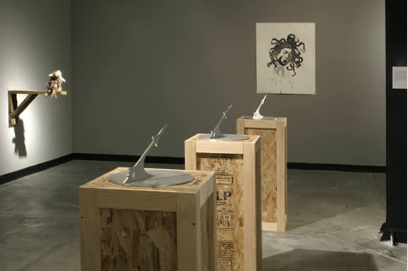 Three shipping crates with abstract sculptures on top.