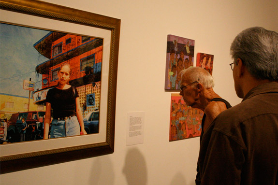 Two figures looking artwork