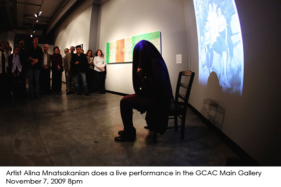 Hooded woman sitting on a chair "Hidden Wounds, Paper Bullets"