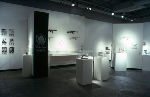 Charles Krafft installation. Shotguns hang on a wall.