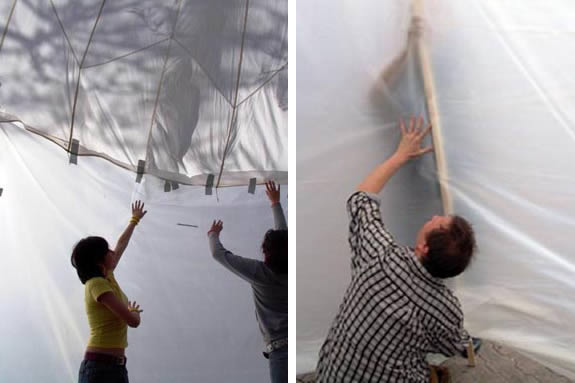 two people pushing onto a white tent