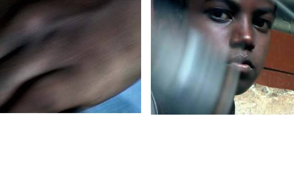 film still of blurry hand and image of a boy looking into the camera