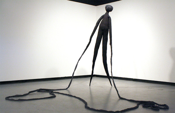 Black Sculpture of tall creature with long arms