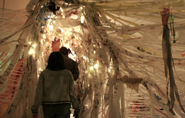 Two people walking through light sculpture