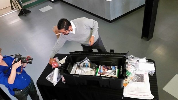 Man reaches for an item next to the time capsule