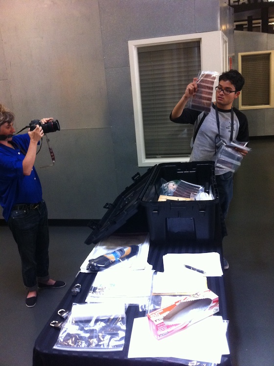 Person taking photographs of another person looking through the time capsule