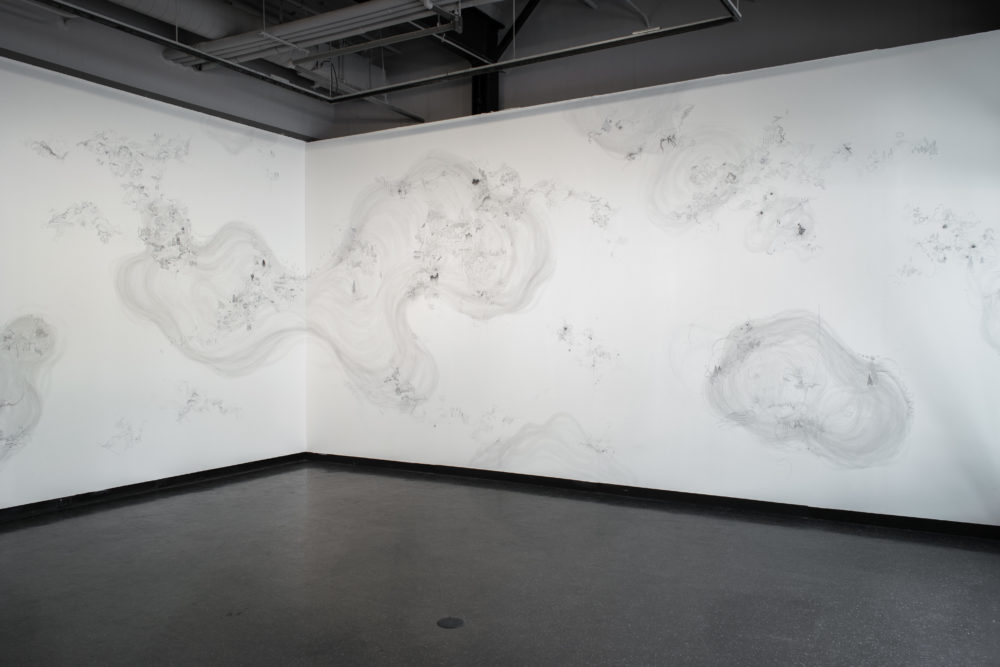 The mural is predominantly white, with intricate, almost microscopic details drawn in shades of gray.