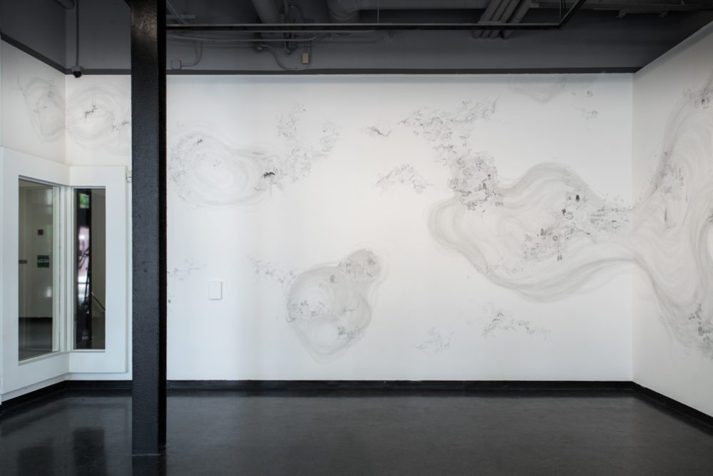 The mural is predominantly white, with intricate, almost microscopic details drawn in shades of gray.