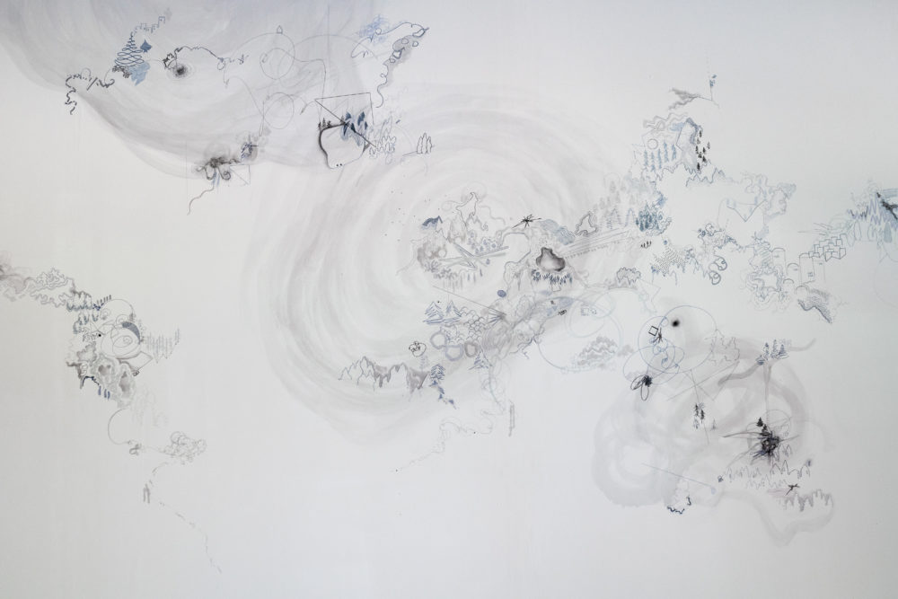 The mural is predominantly white, with intricate, almost microscopic details drawn in shades of gray.