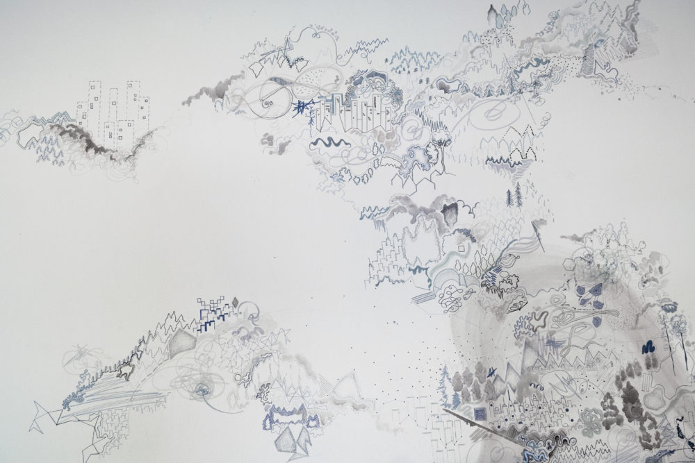 The mural is predominantly white, with intricate, almost microscopic details drawn in shades of gray.