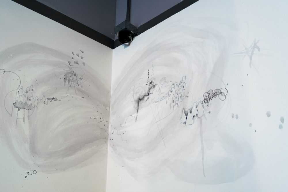 The mural is predominantly white, with intricate, almost microscopic details drawn in shades of gray.
