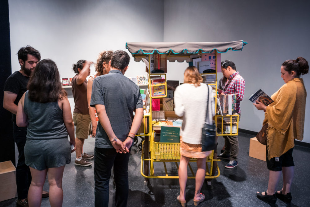 People gathered around sculpture and reading books