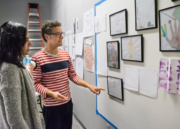 Paul Ramirez Jonas displaying customers’ completed art assignments.