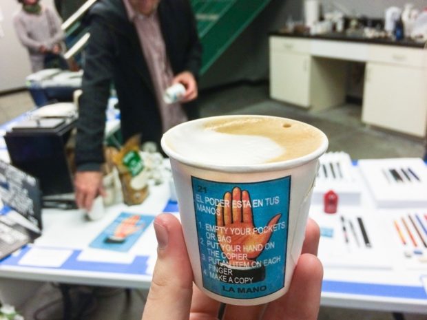 Cups at Dayjob Espresso and Culture displaying €˜La Mano’ art assignment.