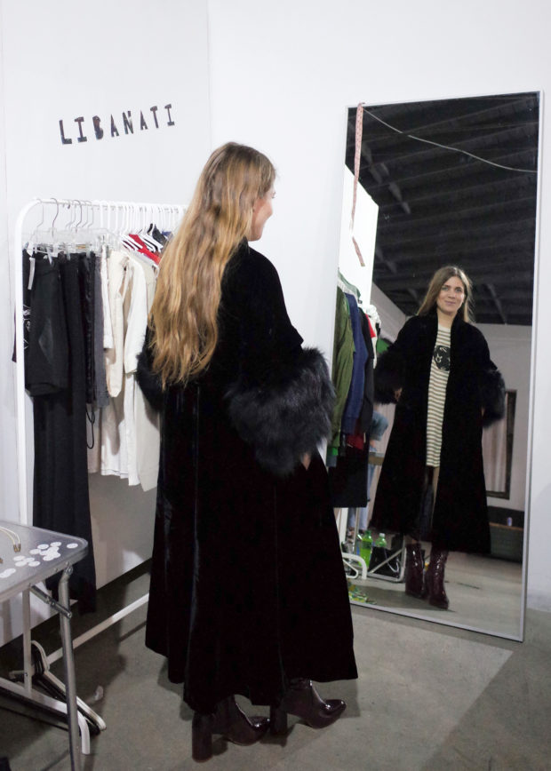 Customer trying on bacl fur coat in Libanati pop-up shop