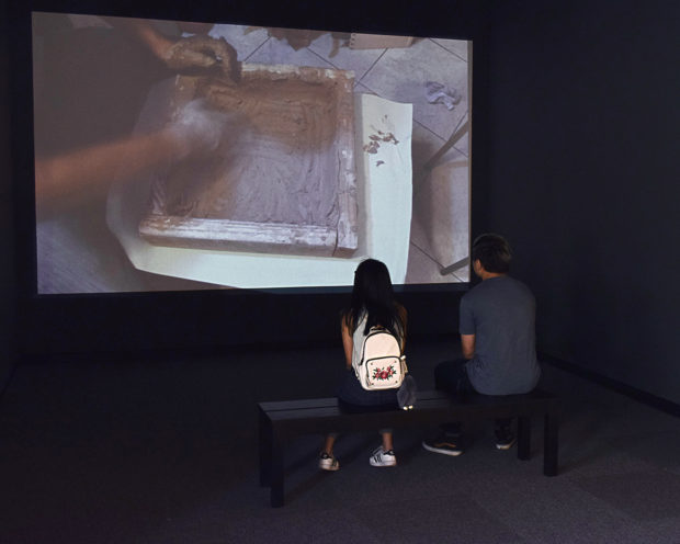 two people watching video of worm compost trays being made