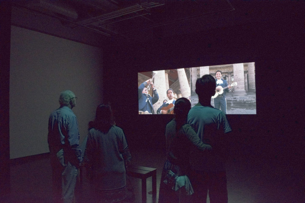 Figures watching video installation