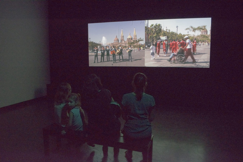 Figures watching video installation