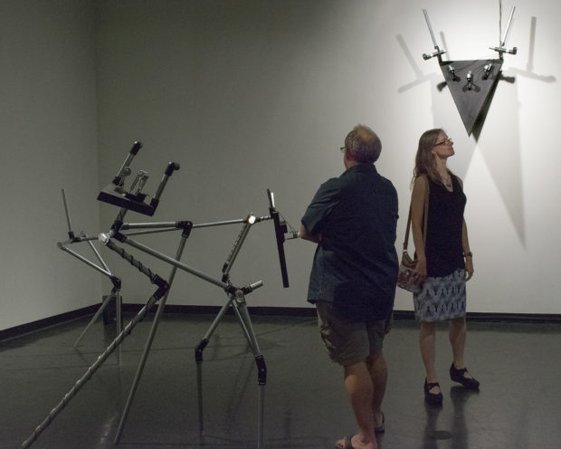 metal installations in art gallery with patrons looking at artwork