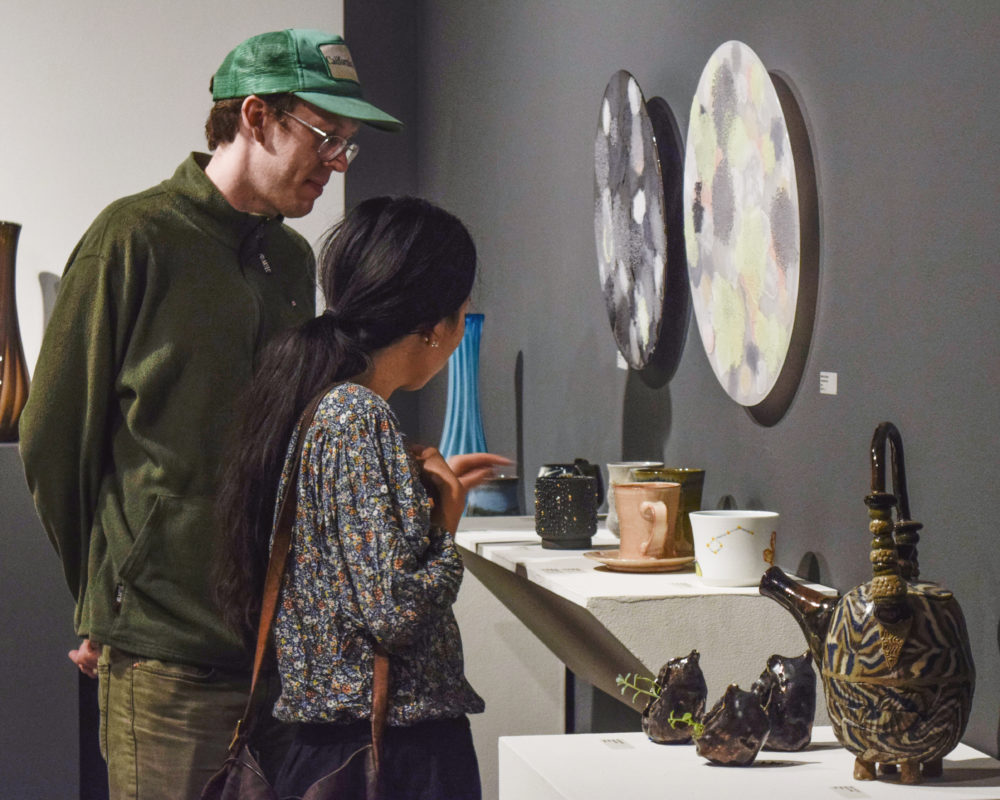 COUPLE LOOKING AT CERAMIC MUGS