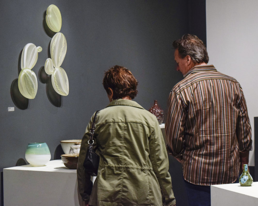 OLDER COUPLE LOOKING AT CERAMIC WORK