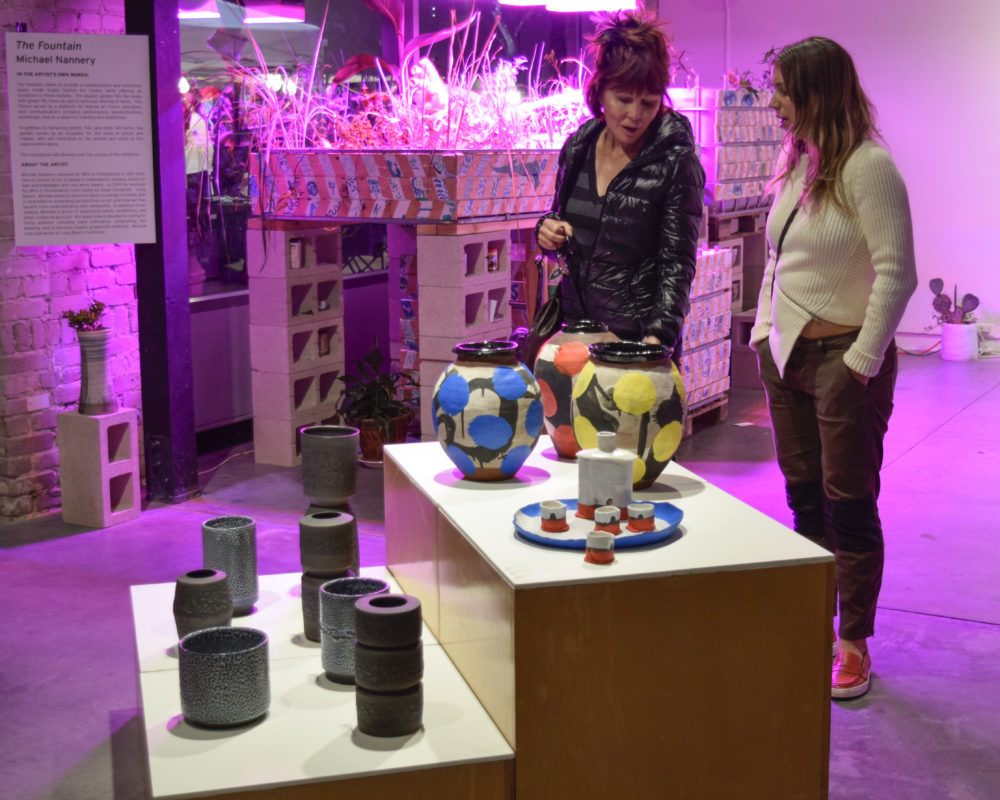 mother and daughter looking at centerpiece of glass and ceramic show and sale