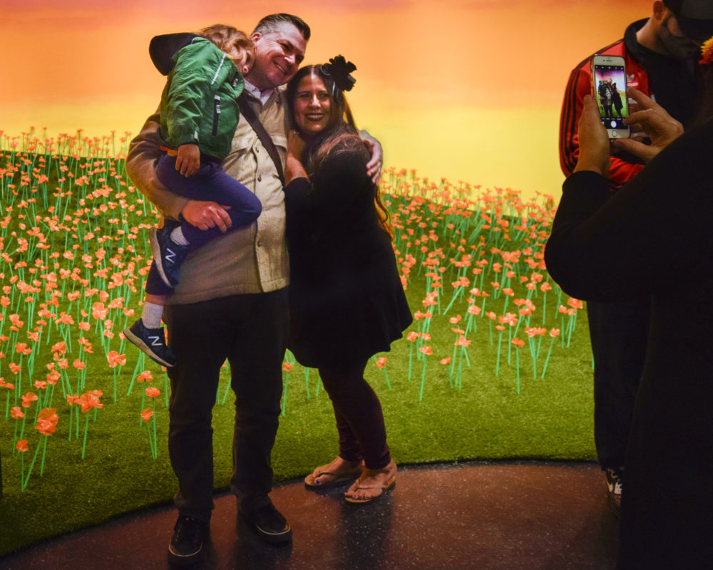 FAMILY TAKING A PHOTOGRAPH INFRONT OF SUPERBLOOM EXHIBITION