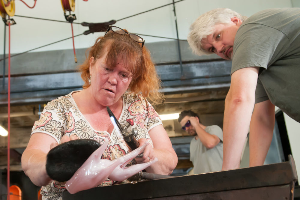 female and male blowing glass