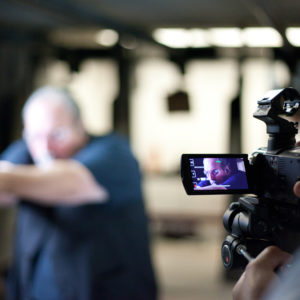 Individual filming a person shooting a gun