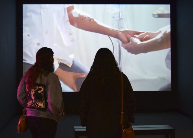 Two people standing watching Exchange