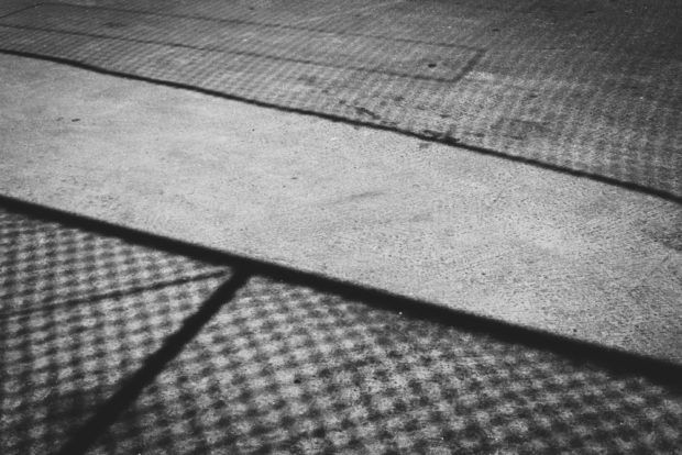 shadow of wire fence on sidewalk