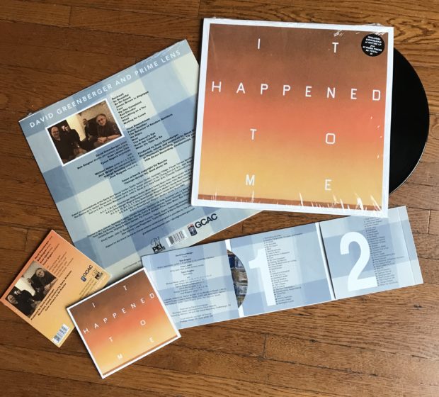 A vinyl record and a cd over a wooden surface