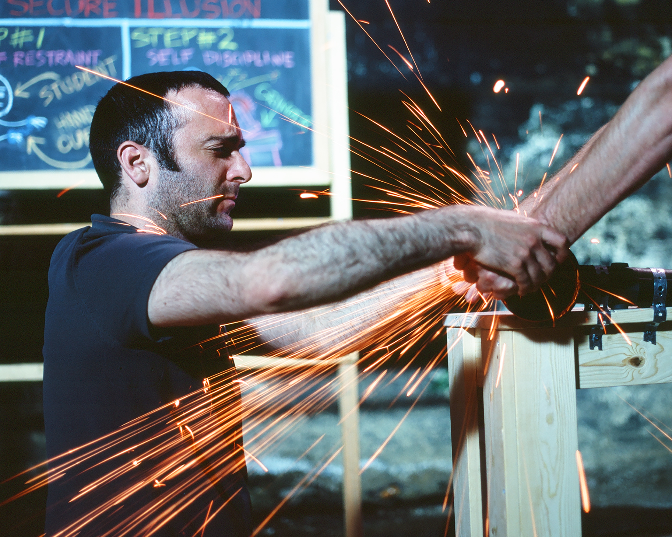 Artist teaching person to weld