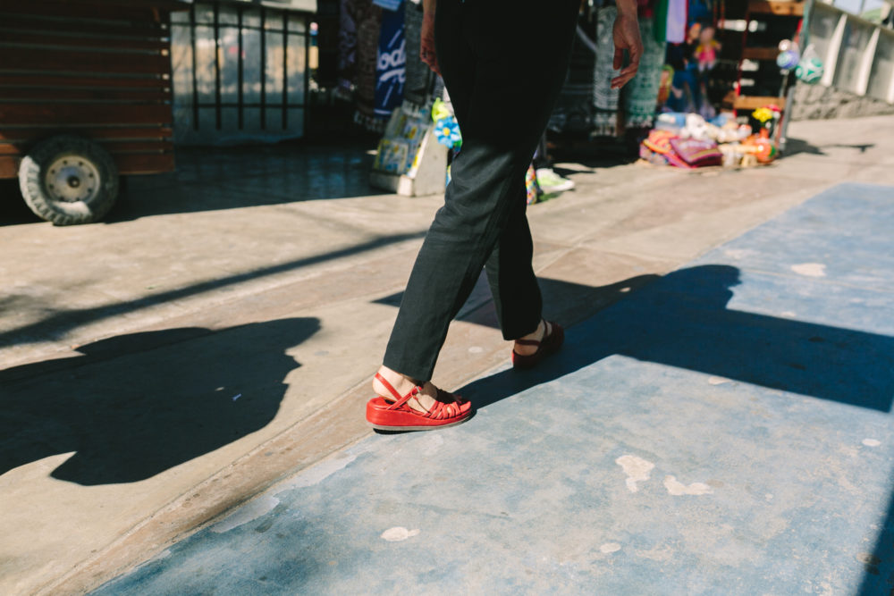 individual in red shoes walking on sidewalk