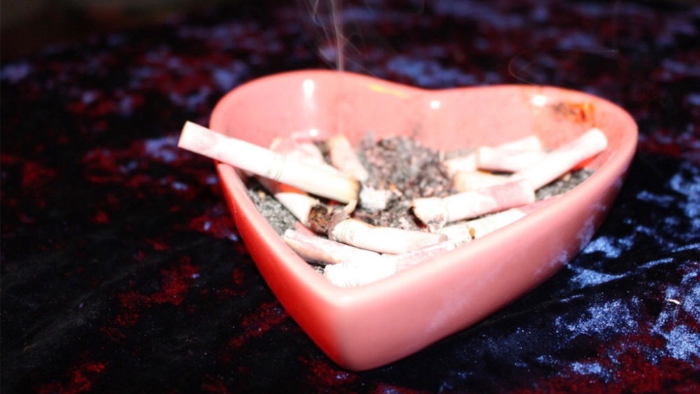 Heart-shaped ash tray with cigarettes in it. 