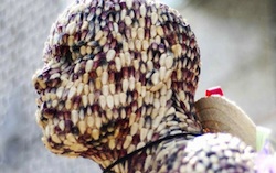 A human face covered in corn grains