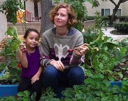 A woman and a girl holding a radish.