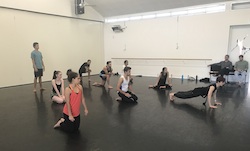 A group of people stretching in a classroom