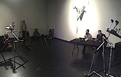Two men sitting on a table surrounded by metallic structures