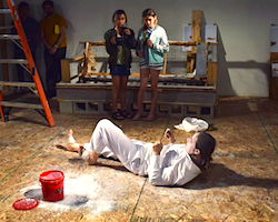 Artist Kim Zumpfe  performing laying on the floor