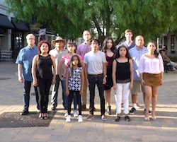 A group of diverse individuals standing on a promenade looking to the camera