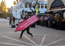 A sign spinner performing in front of a crowd