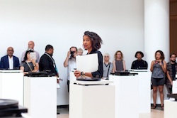 Artist Lauren Woods standing among pedestals