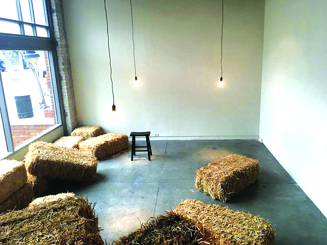 hay stacks and small bench in small lit room