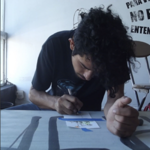image of artist Andres Byeck drawing at a table
