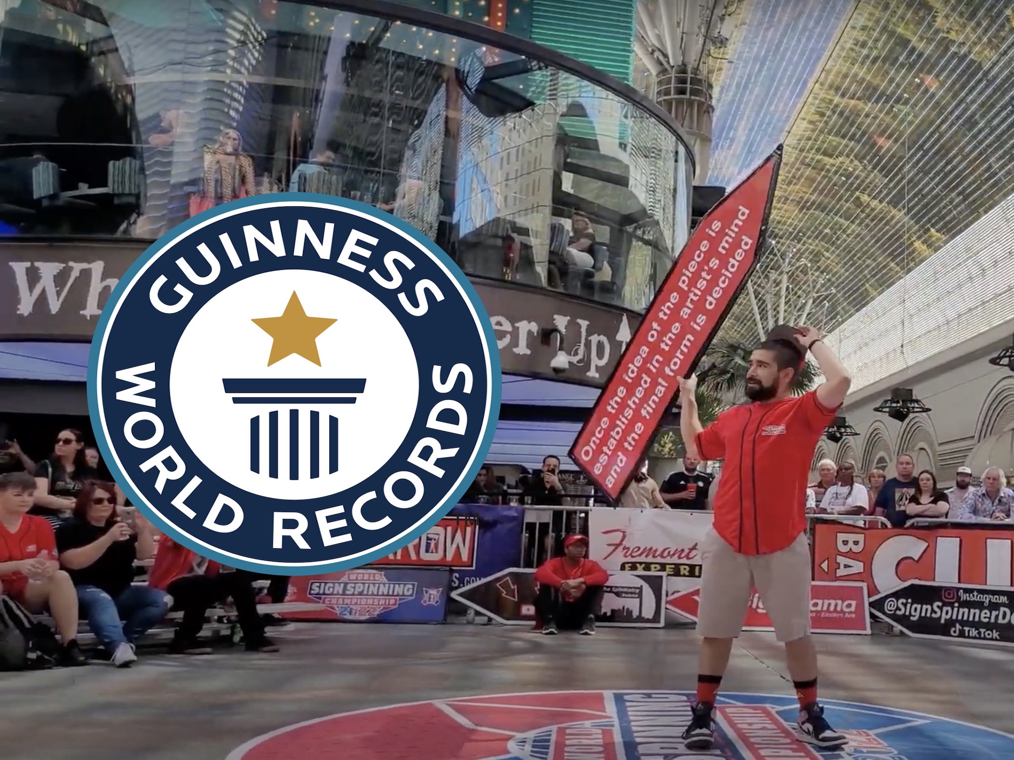 Man flipping a sign in front of a crowd with "Guinness World Record" sign in front