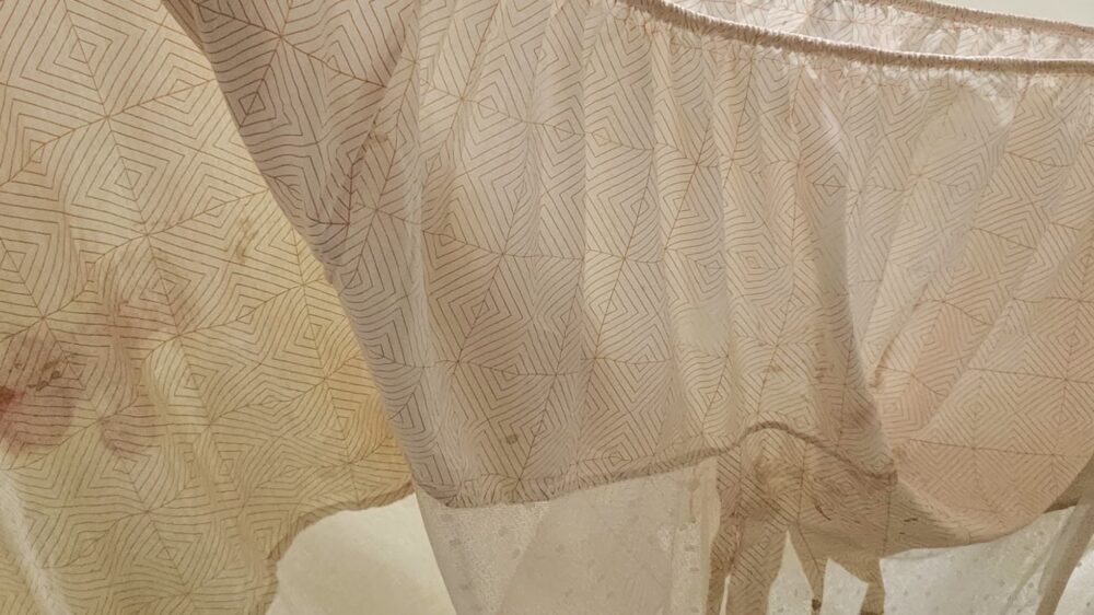 layered tan bed sheet fabric with stains